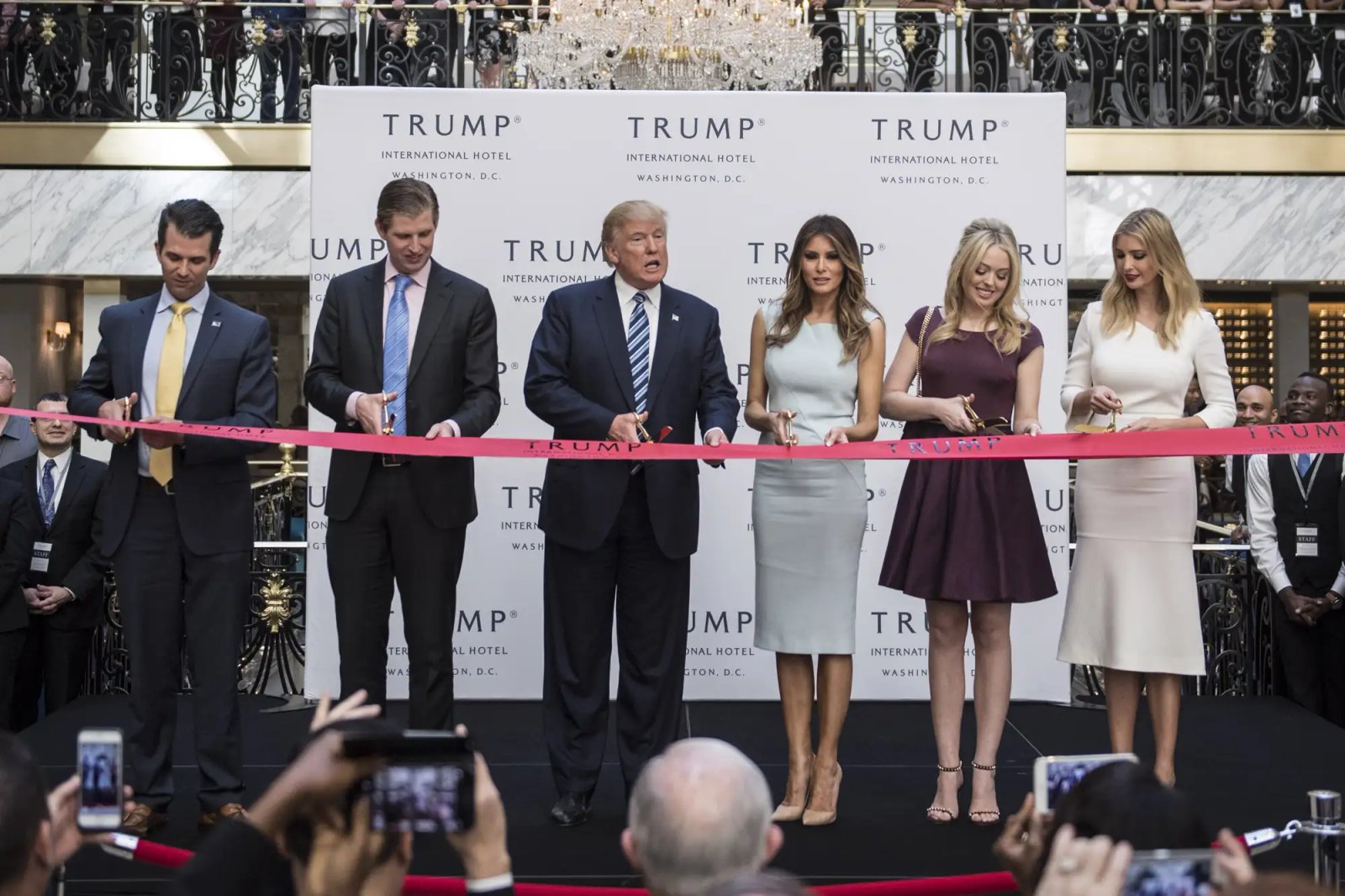 Republican presidential candidate Donald Trump, accompanied by, from left, Donald Trump Jr., Eric Trump, Trump, Tiffany Trump, Melania Trump, and Ivanka Trump, prepare to cut a ribbon during the grand opening ceremony of the Trump International Hotel- Old Post Office in Washington, DC on Wednesday October 26, 2016.