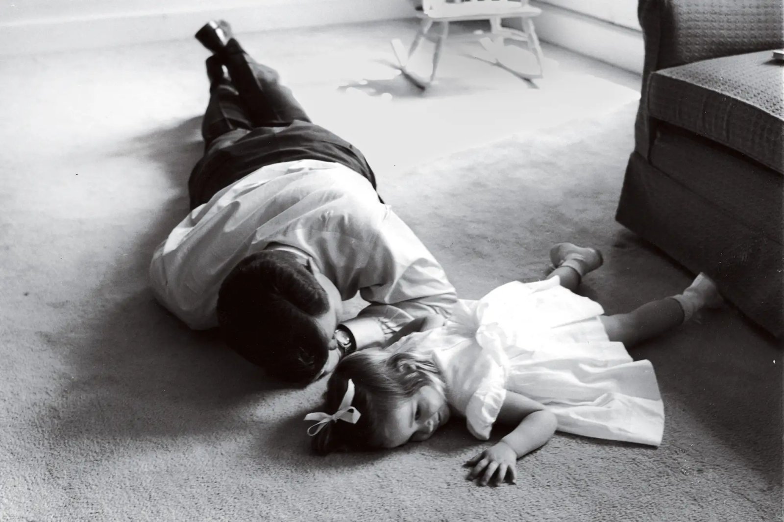 Senator (and future US President) John F. Kennedy (1917 - 1963) lies on the floor with his daughter Caroline, Hyannis Port, Massachusetts, late 1950s or early 1960s.
