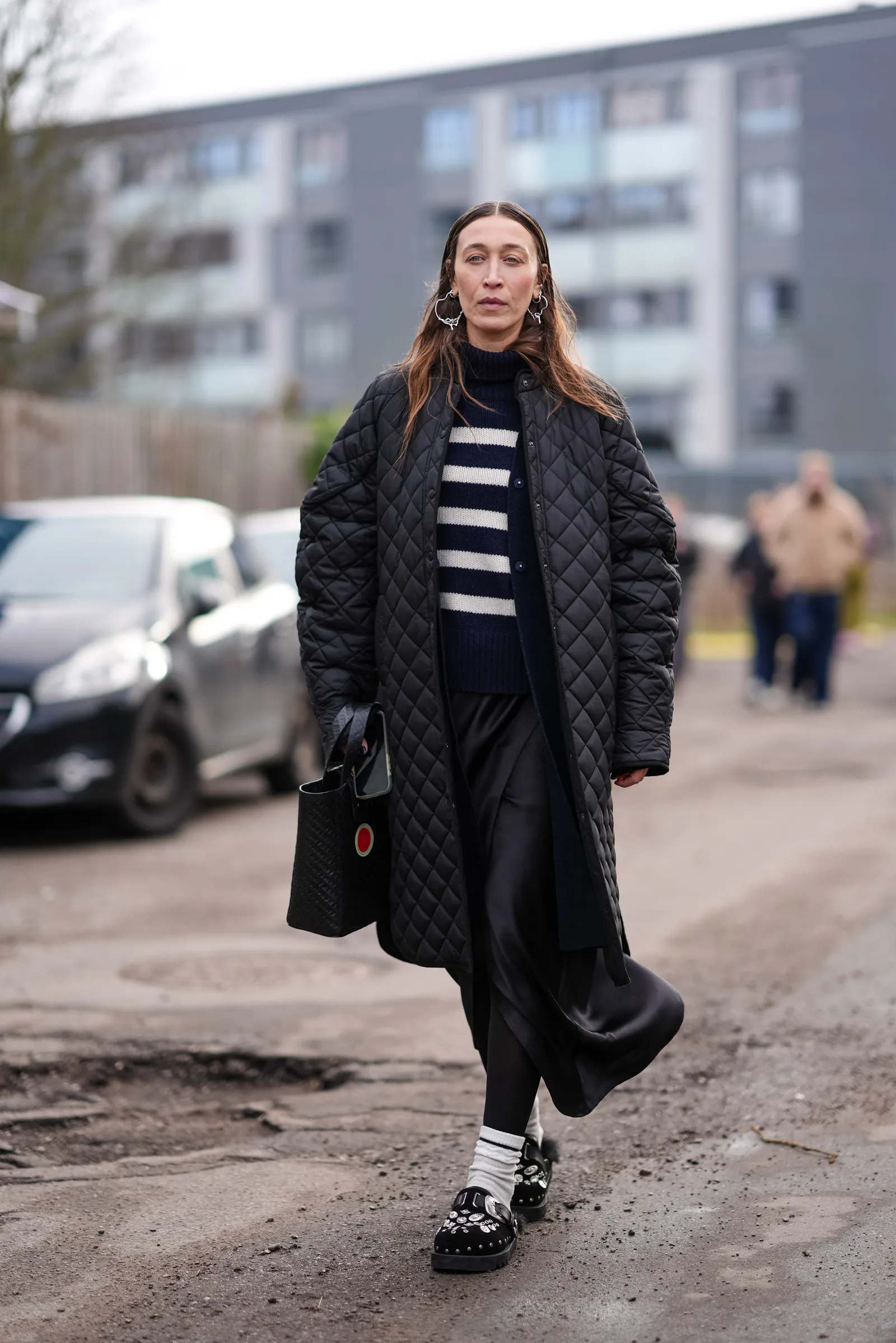 COPENHAGEN DENMARK  JANUARY 31 Alana Hadid wears large earrings a black padded  quilted long jacket  a black and white...