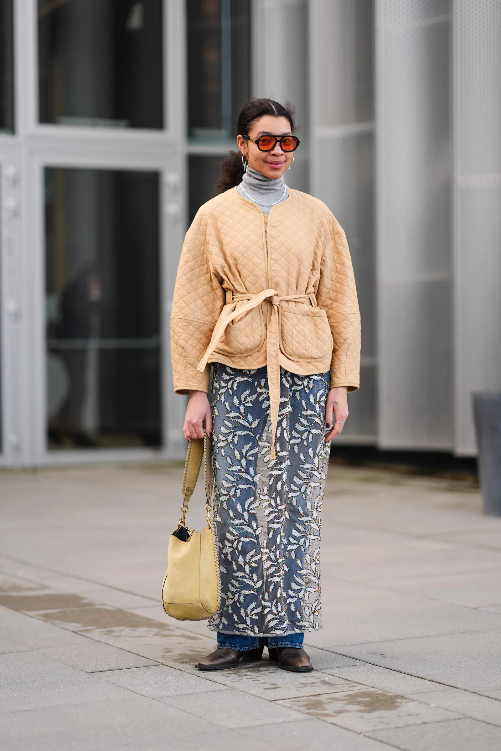 COPENHAGEN DENMARK  FEBRUARY 01 A guest wears orange sunglasses a gray turtleneck  a beige padded jacket  a mesh floral...