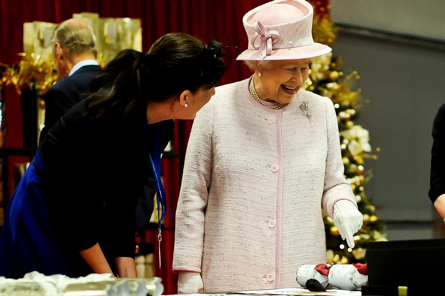Queen Elizabeth II is shown how her Christmas crackers are made during a visit to International Greetings UK Ltd at the Penallta Industrial Estate in Ystrad Mynach during her visit to south west Wales on April 30, 2014 in Ystrad Mynach, Wales.