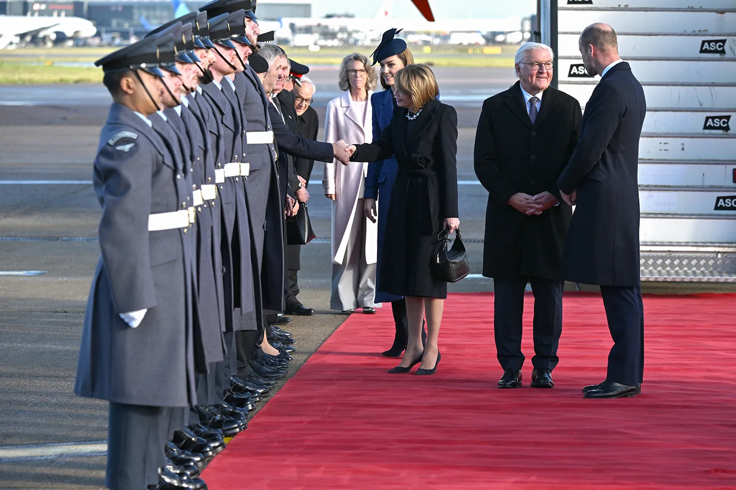 Britain's Prince William (R), Prince of Wales speaks with Germany's President Frank-Walter Steinmeier (2nd R) as Britain's Kate Middleton, Princess of Wales (centre L) introduces dignitaries to his wife Elke Buedenbender (centre R) during their arrival at London Heathrow Airport.