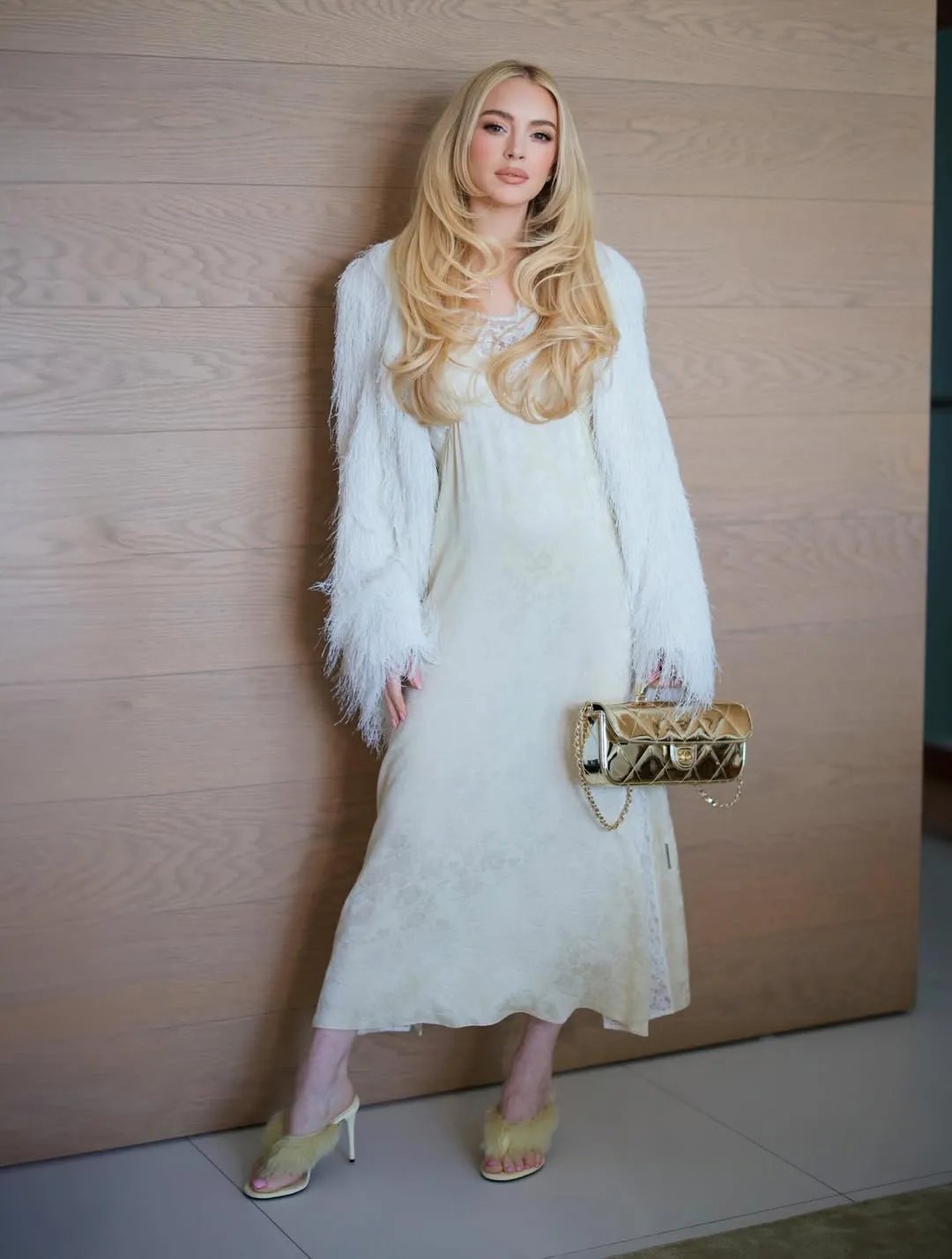 Lindsay Lohan wearing a white slip dress with heeled flip-flops.