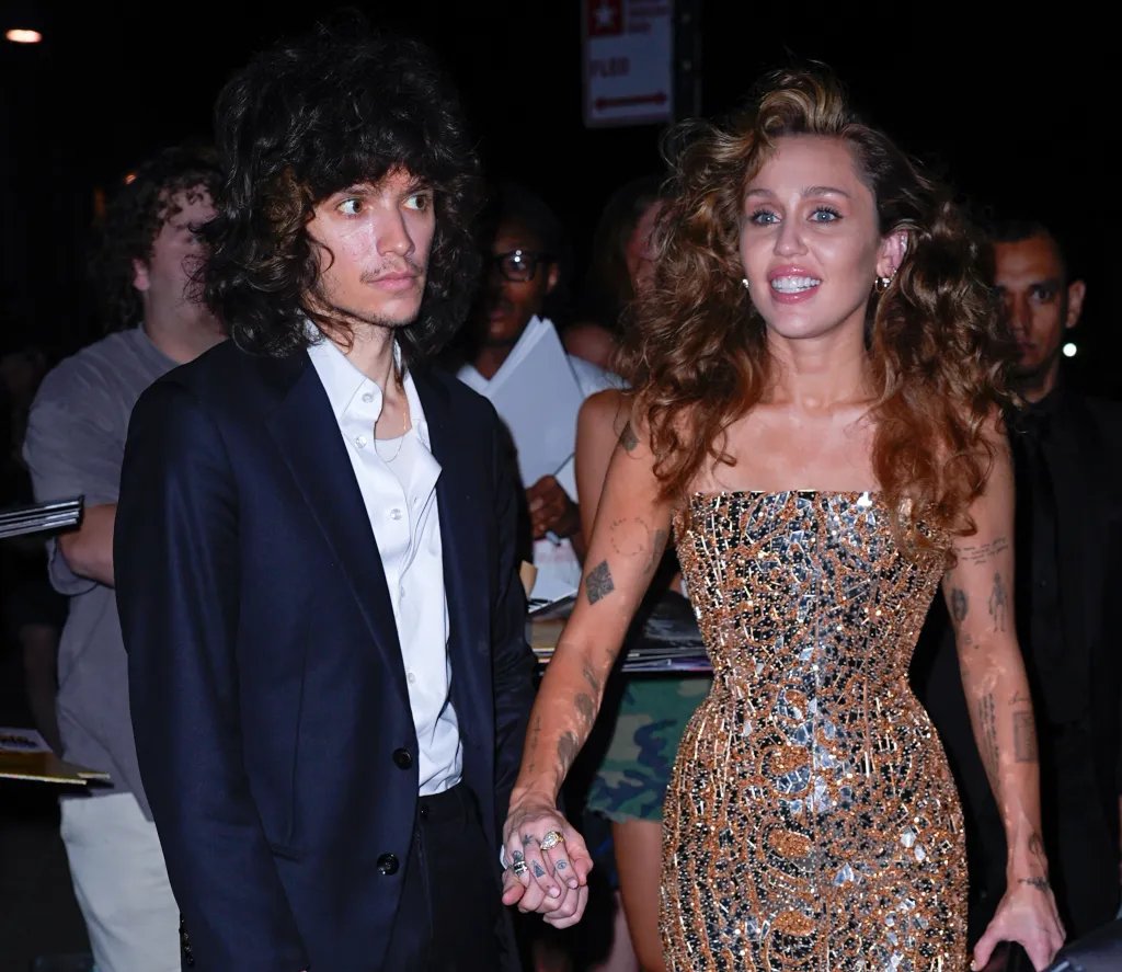 Miley Cyrus and Maxx Morando holding hands.