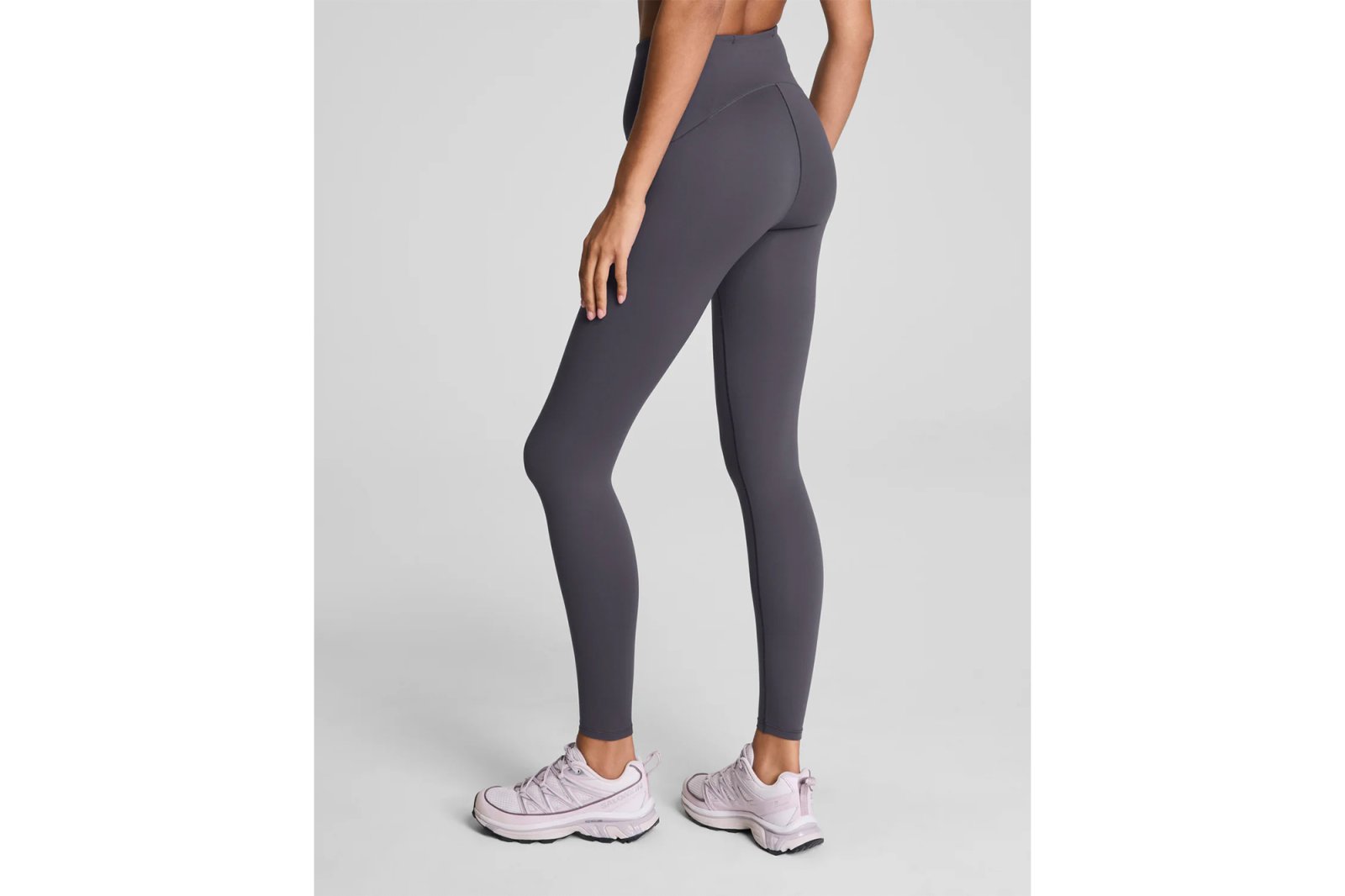 Woman wearing gray leggings and pink athletic shoes.