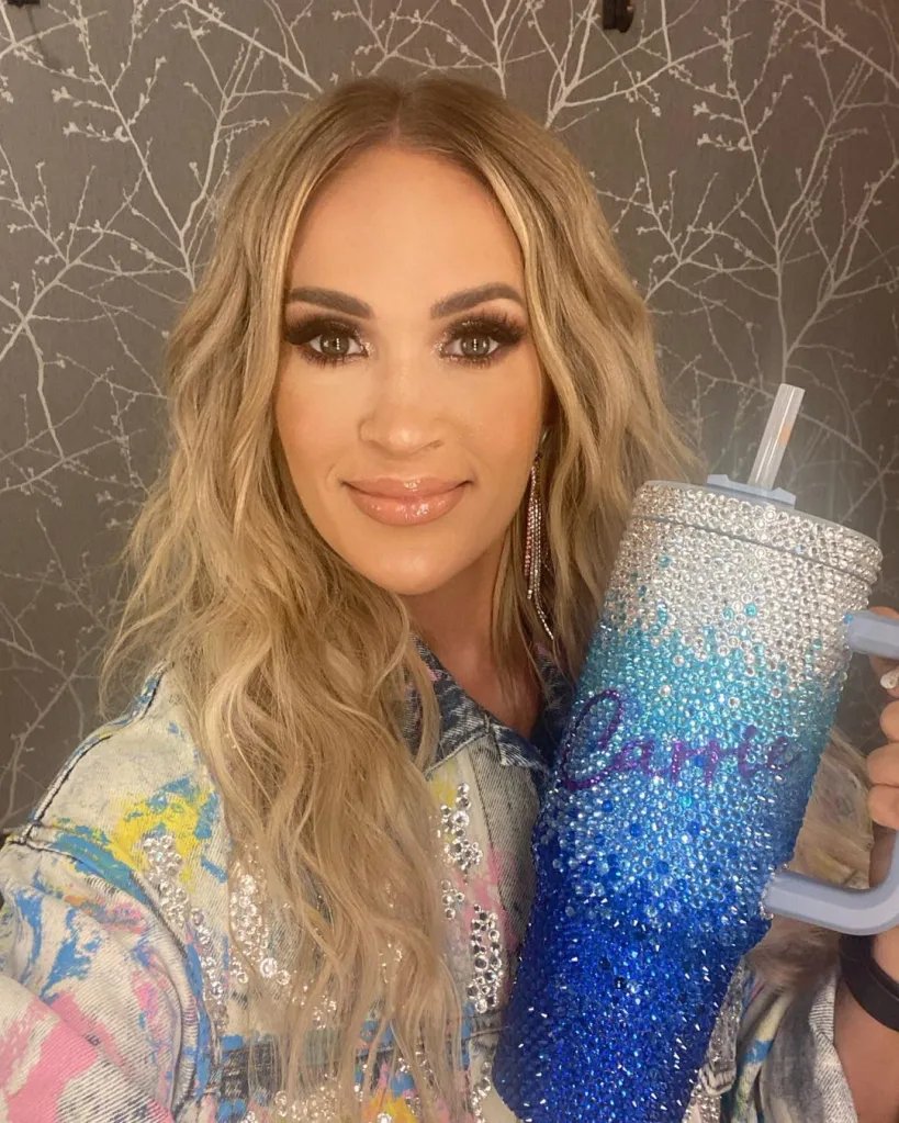 Carrie Underwood holds a blue, crystal-embellished Stanley tumbler.