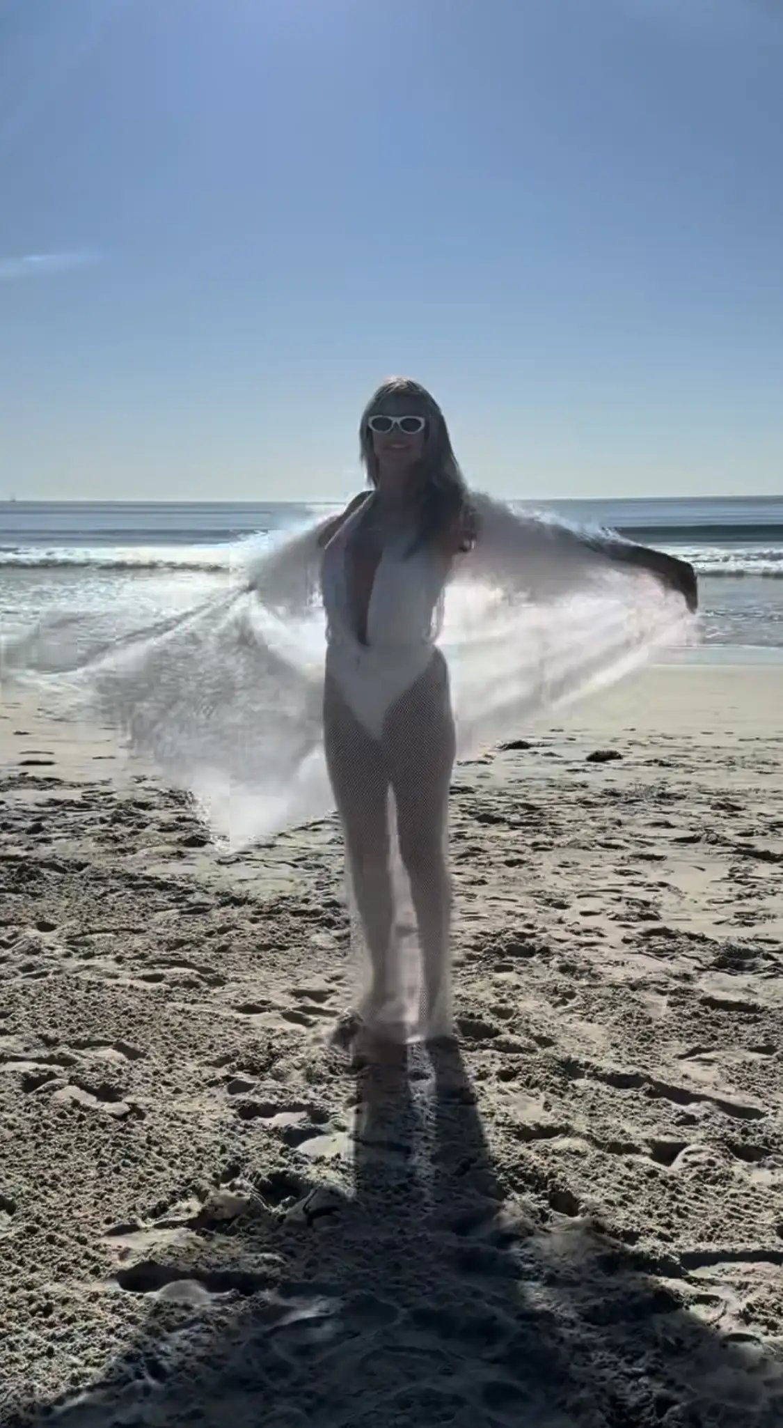 Heidi Klum wearing a sheer dress on the beach