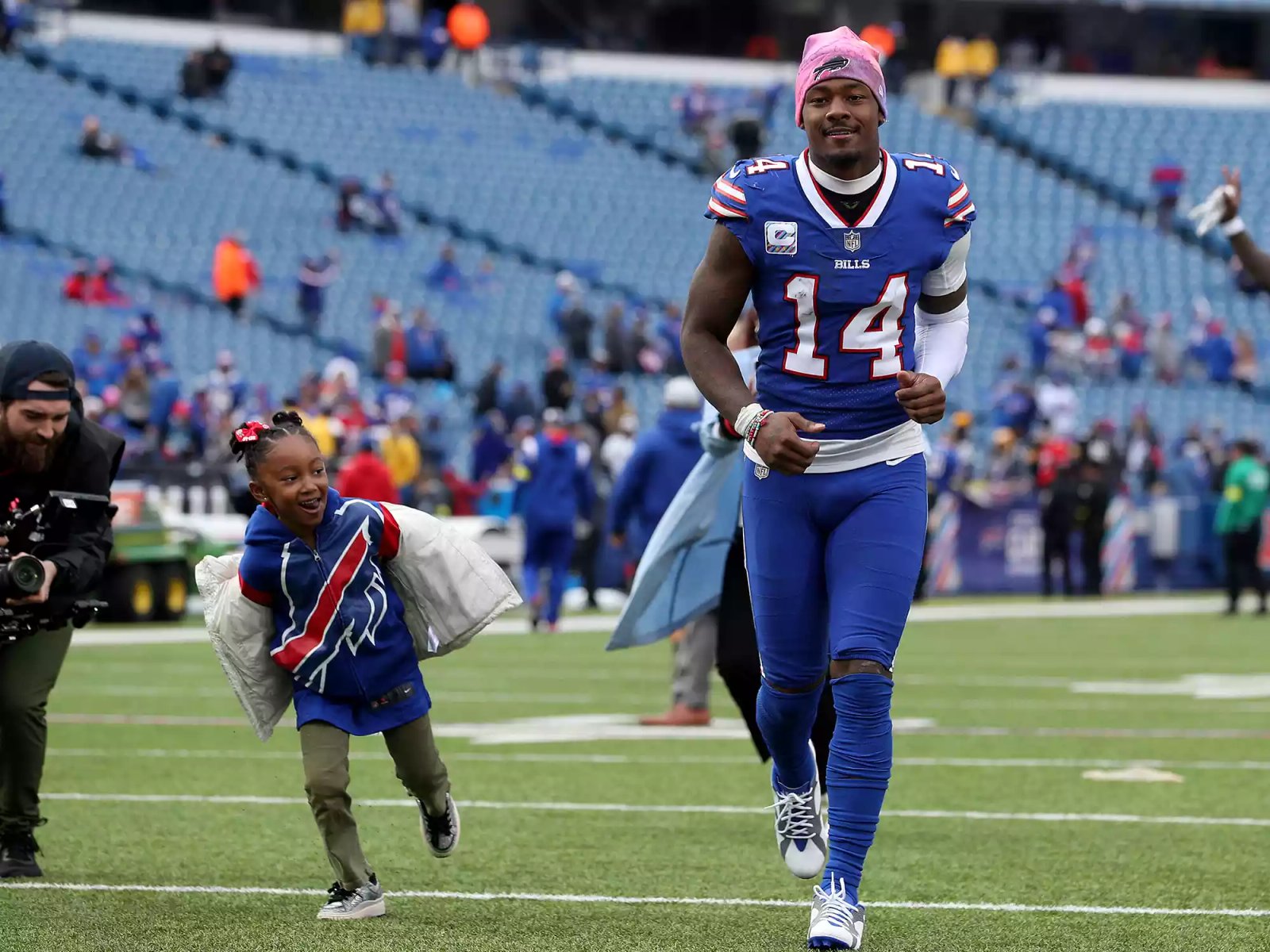 Stefon Diggs and his daughter Nova Diggs on the field after a game against the Pittsburgh Steelers at Highmark Stadium on October 09, 2022.