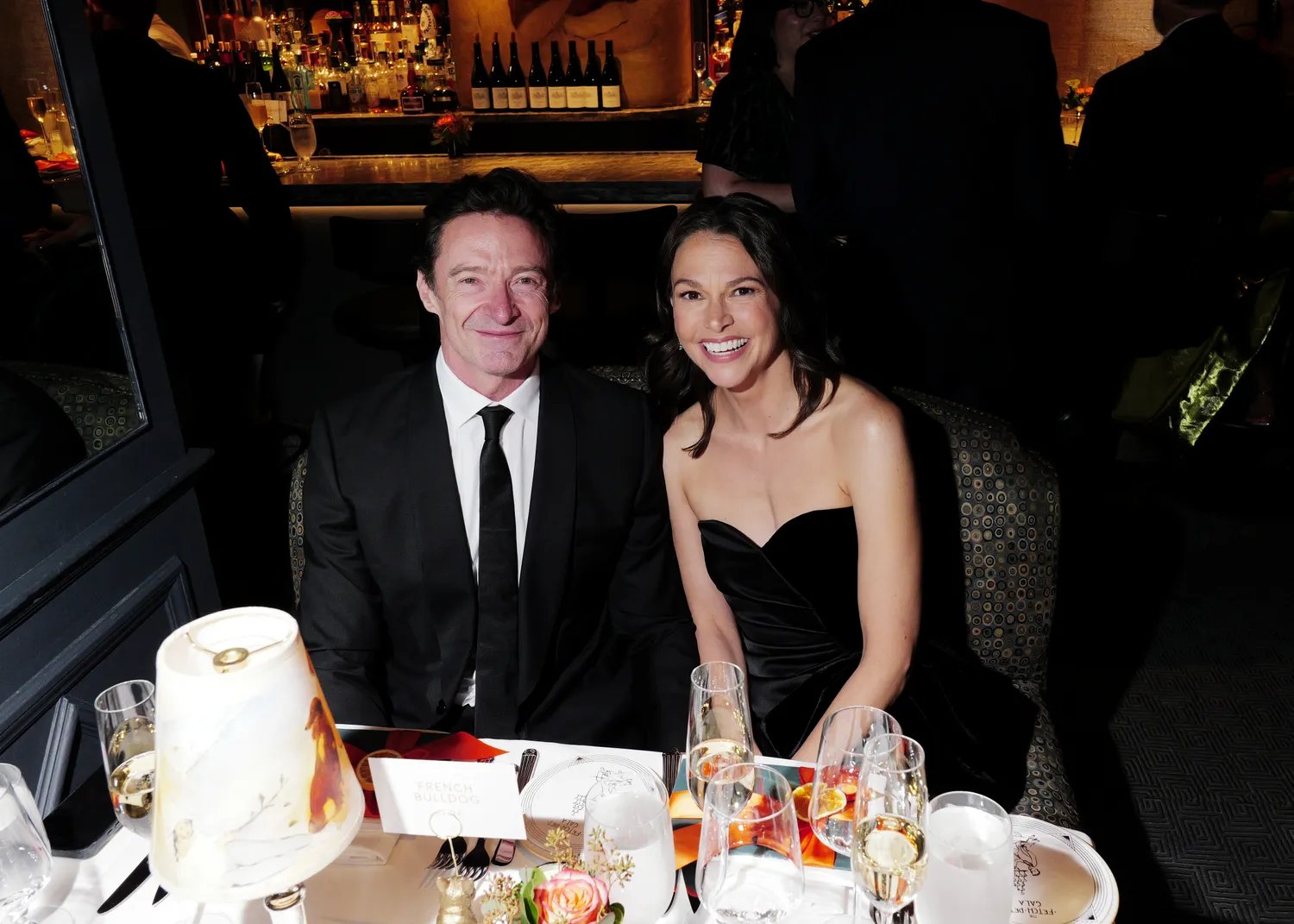 Hugh Jackman and Sutton Foster smiling at a table in October 