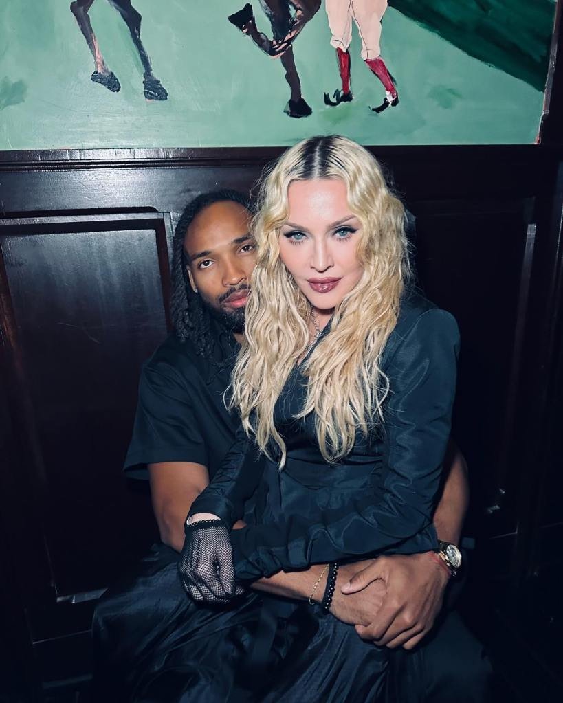Madonna sitting on Akeem Morris's lap.