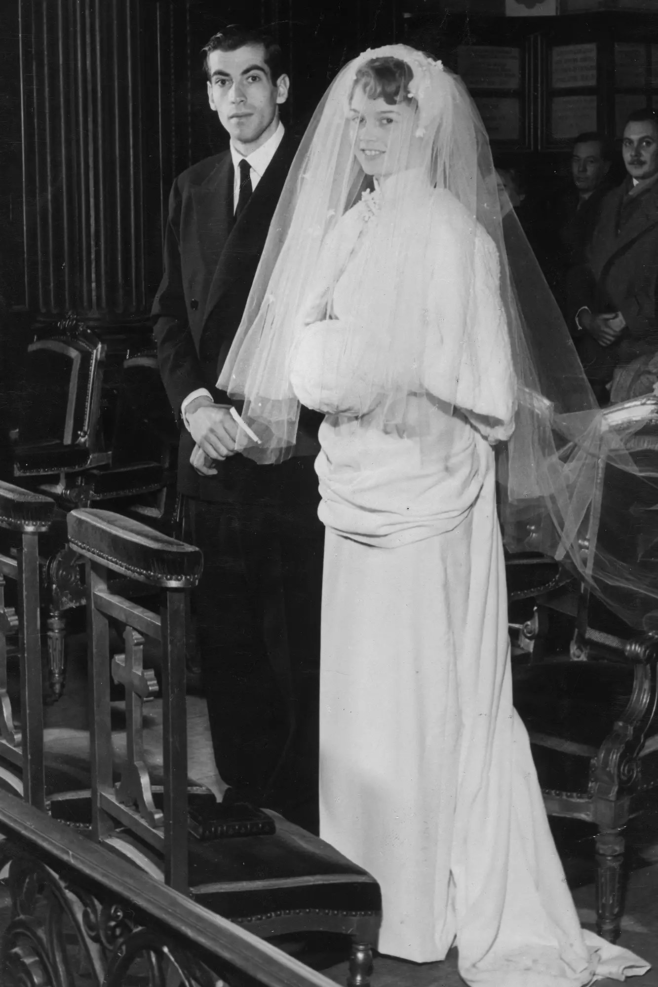 12th December 1952: Full-length portrait of French actor Brigitte Bardot and her husband, French director Roger Vadim (1928-2000), standing at the altar during their wedding ceremony at the Church of Passy, Paris.