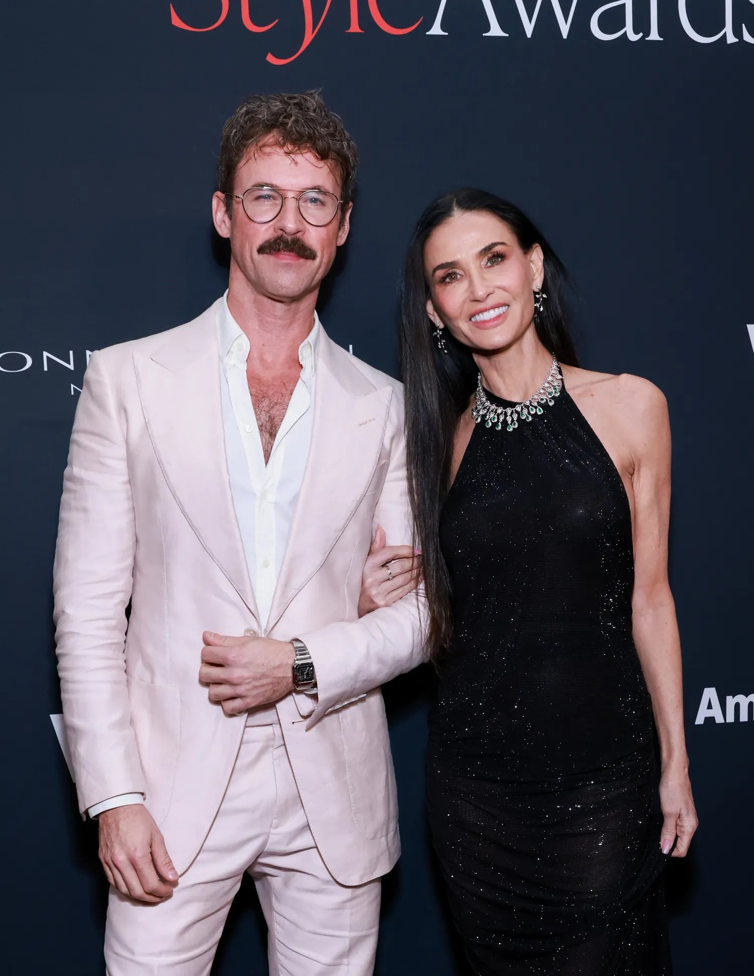 Brad Goreski with Demi Moore in a black dress and diamond necklace at an event