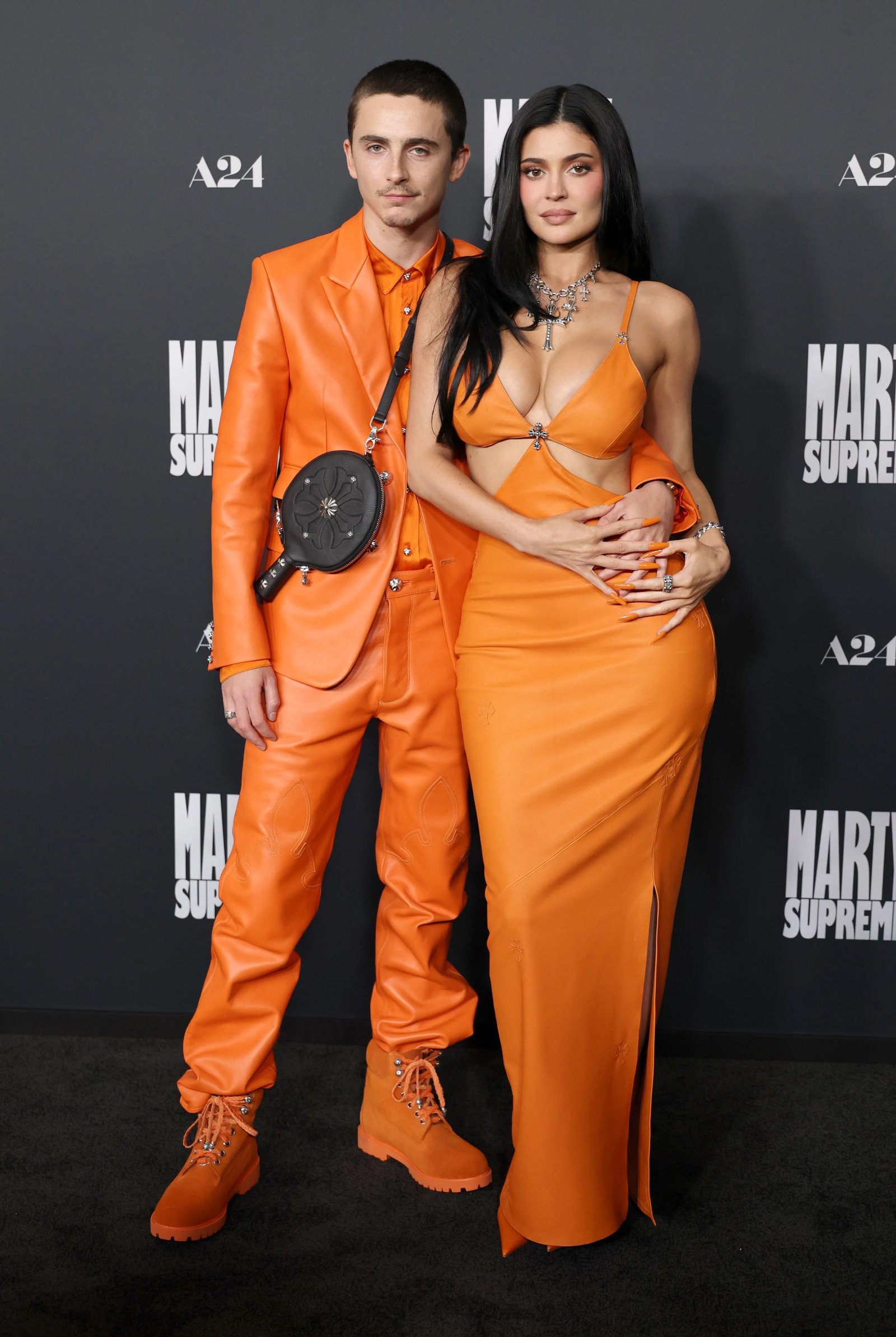 Timothée Chalamet and Kylie Jenner wearing matching "Marty Supreme" orange outfits.