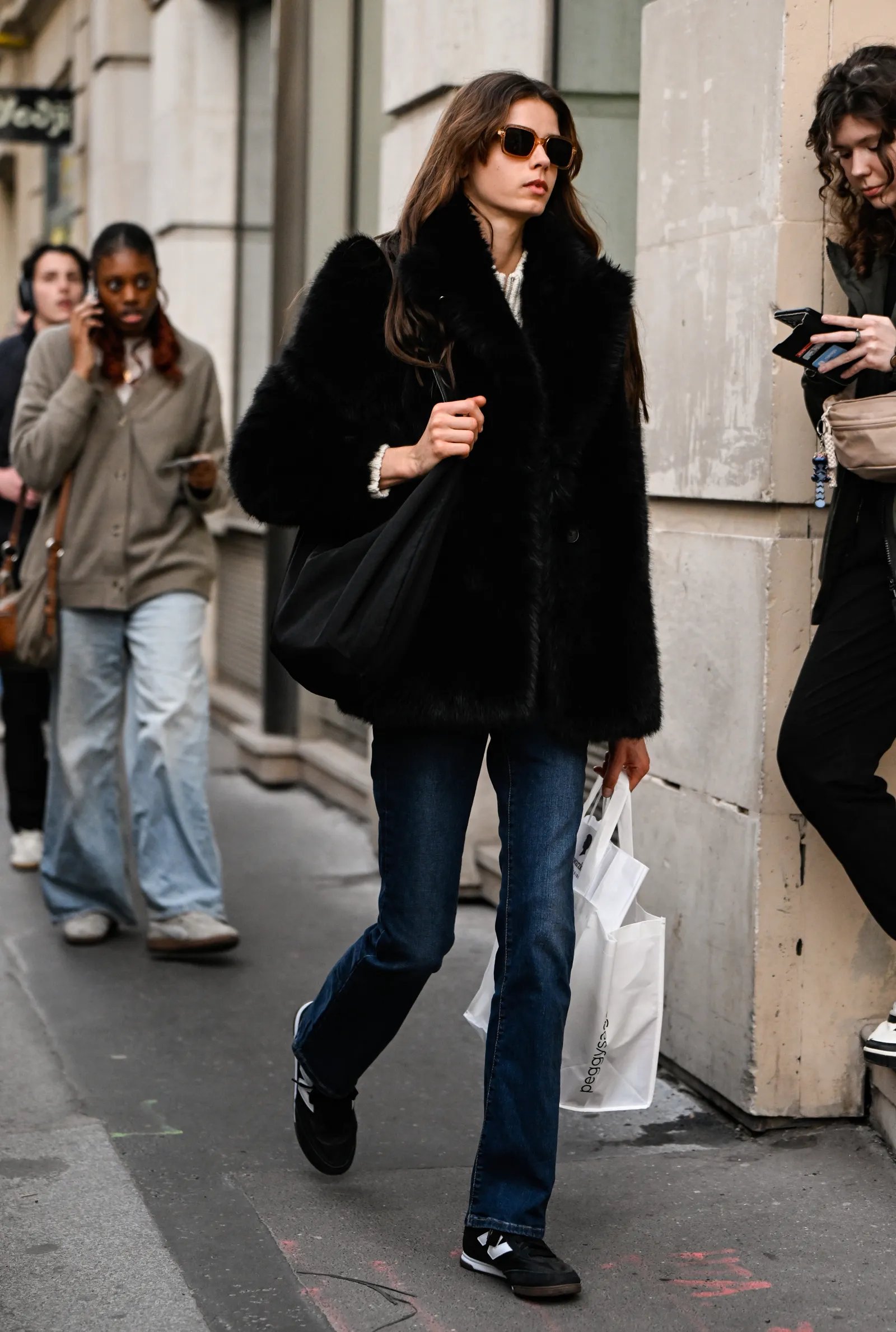 Image may contain Clothing Pants Pedestrian Person Footwear Shoe Accessories Bag Handbag Coat Adult and Glasses