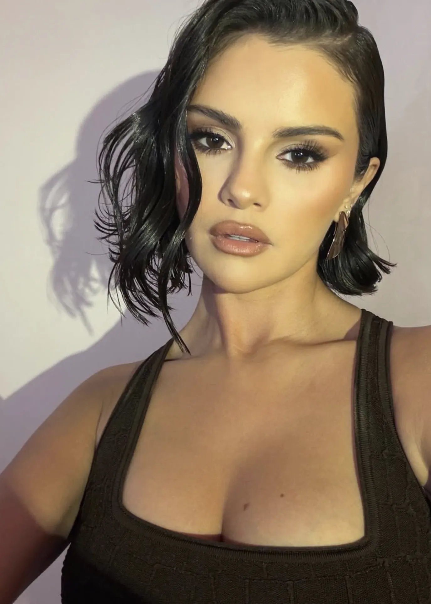 Selena Gomez with wet-effect hair and a glam makeup look in a selfie