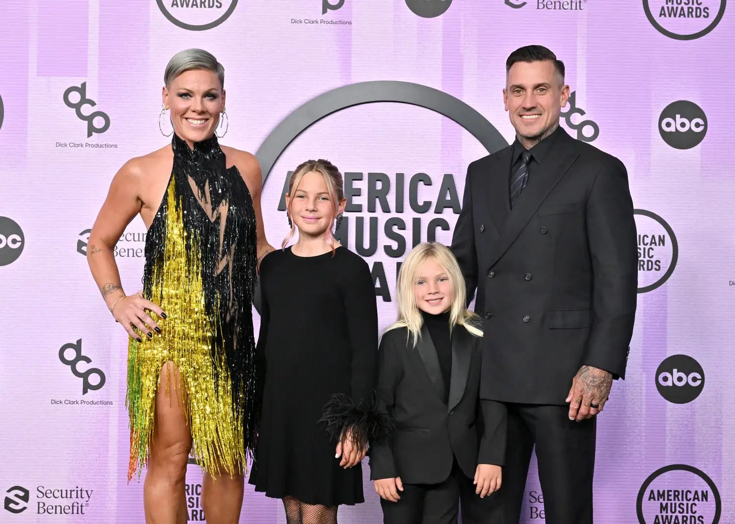 Pink and Carey Hart posing with two children at an event