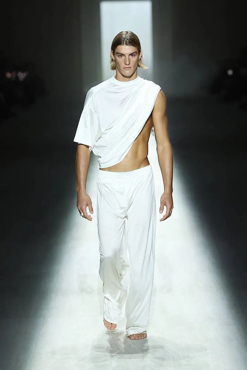 Model walking runway wearing asymmetrical outfit