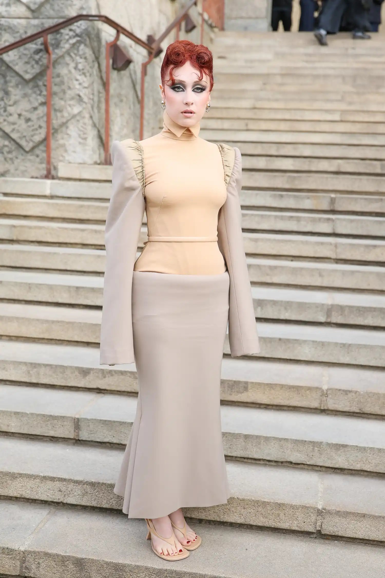 Chappell Roan in a nude corset dress on the steps at Paris Fashion Week