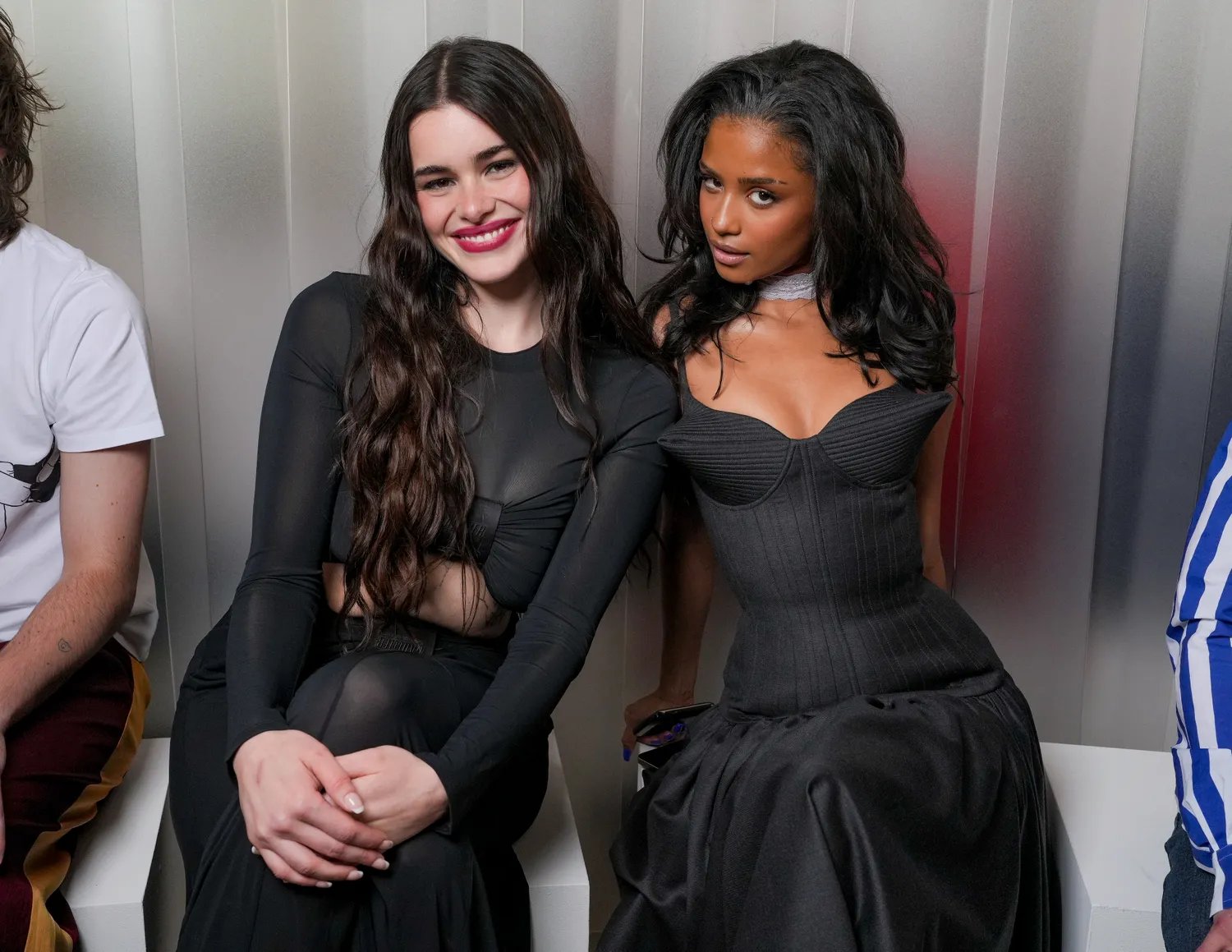 Barbie Ferreira and Tyla sit side-by-side in elegant black dresses at Paris Fashion Week.