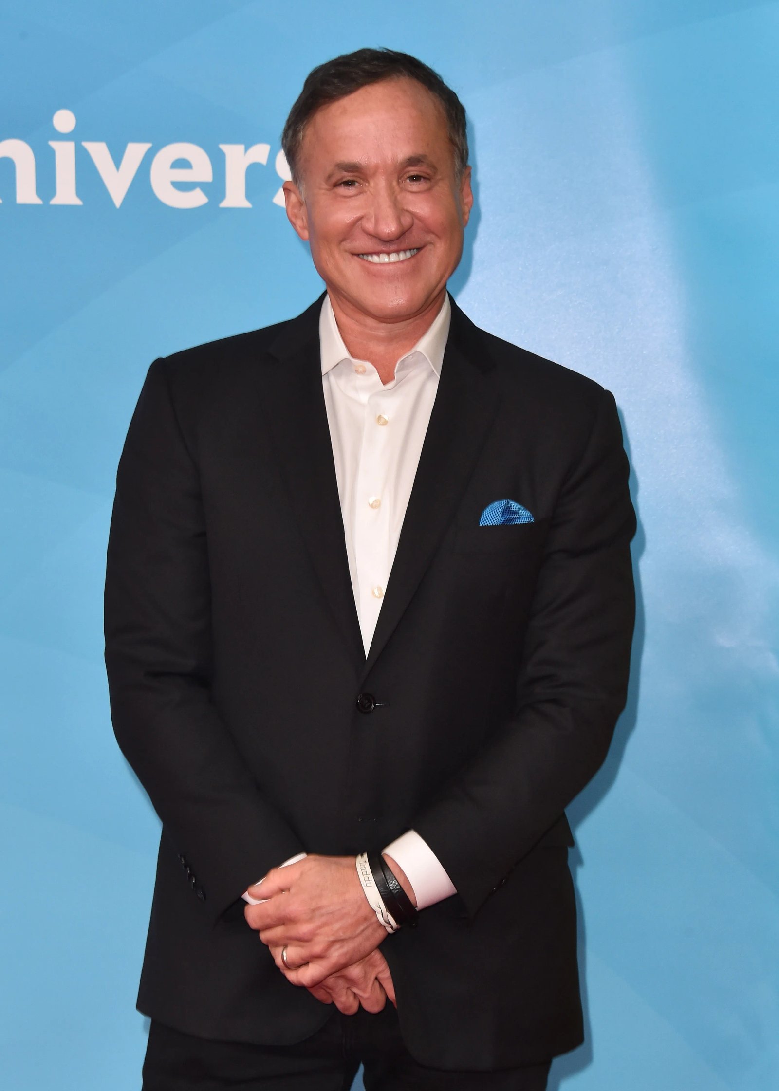 Dr. Terry Dubrow smiling while wearing a black suit jacket and white shirt.