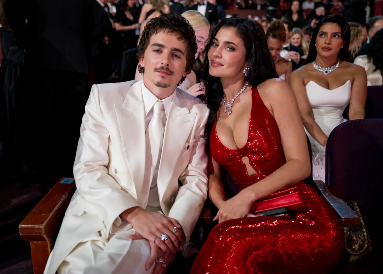 Timothee Chalamet in a white suit with Kylie Jenner in a red gown sitting inside the Oscars