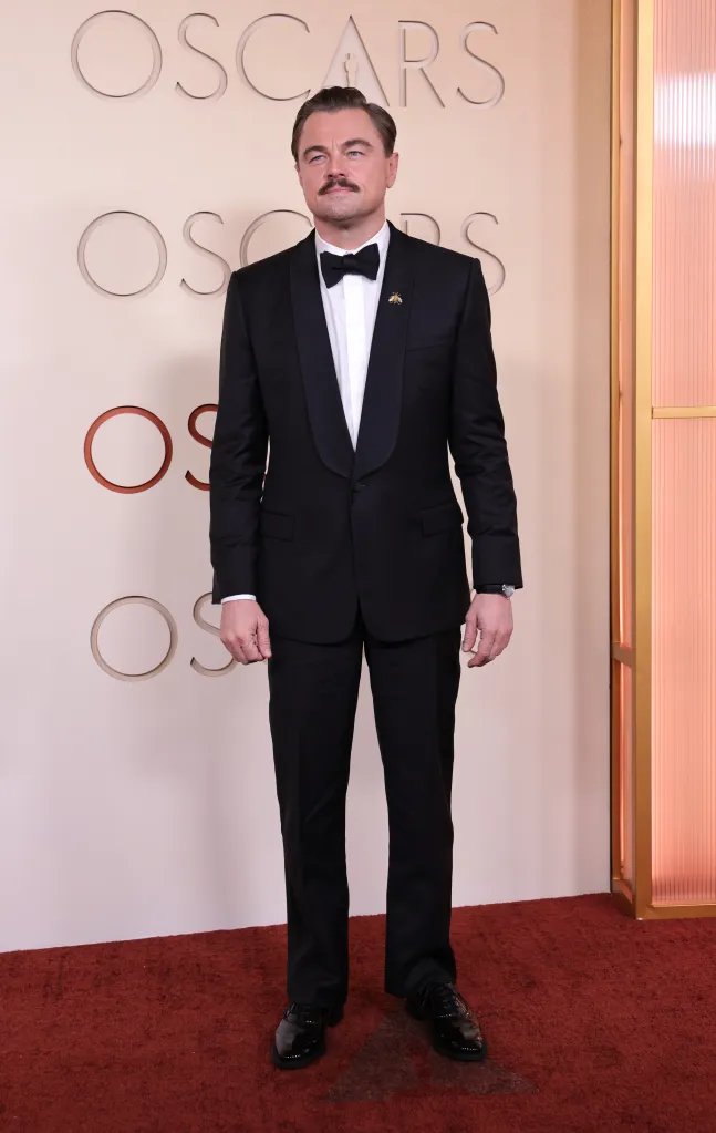 Leonardo DiCaprio in a black tuxedo with a bee brooch at the Oscars.