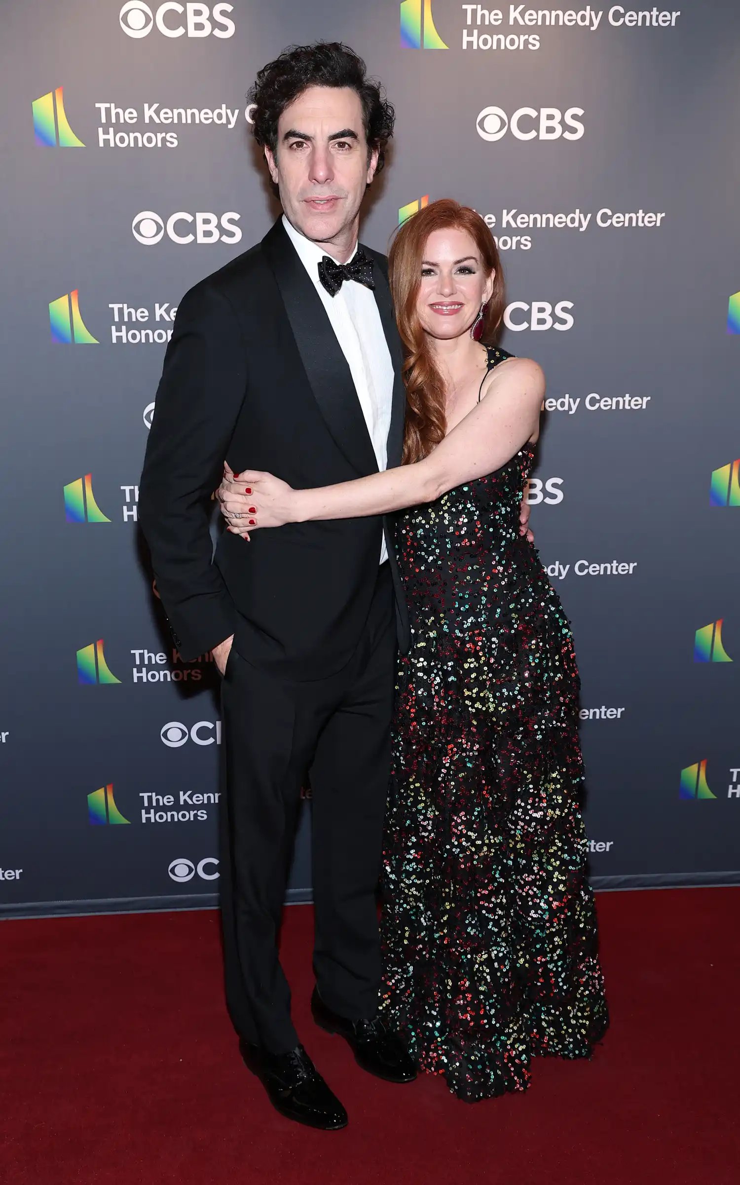 Sacha Baron Cohen and Isla Fisher posing together at the Kennedy Center Honors red carpet
