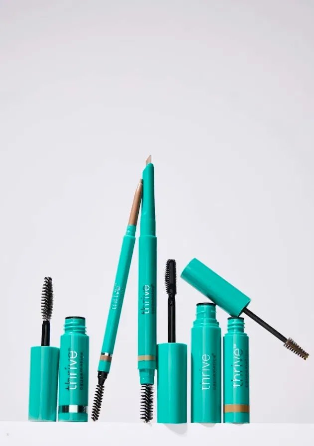 Thrive Causemetics brow and lash products, including mascaras and eyebrow pencils in teal packaging.