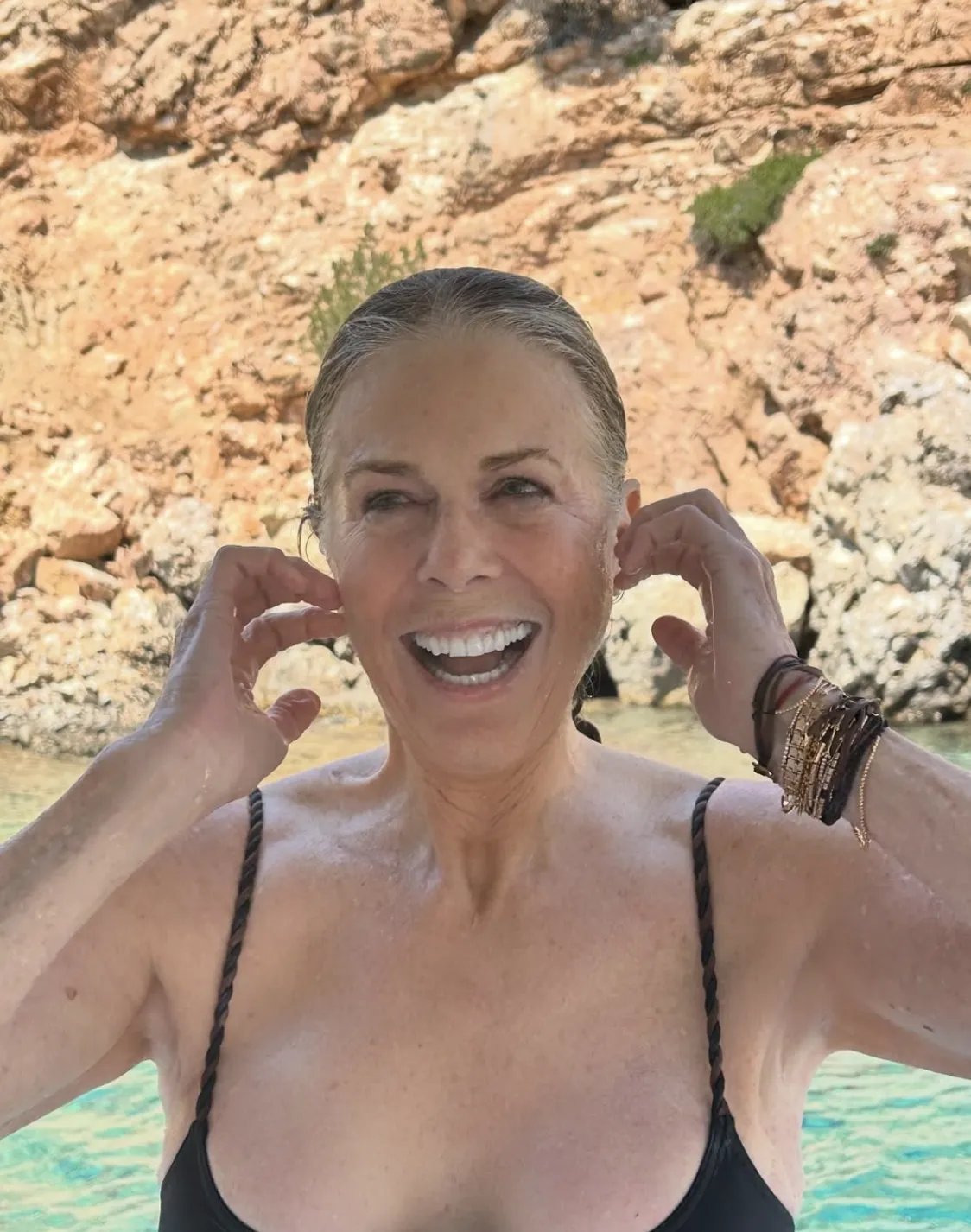 Rita Wilson smiling in a black bathing suit