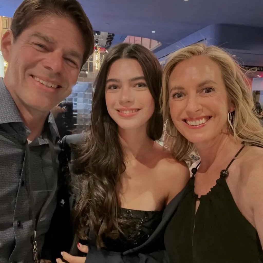 A man, a young woman, and a woman smiling at the camera.