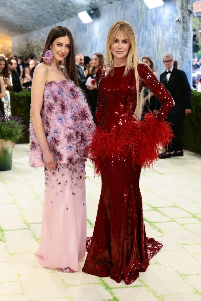 Nicole Kidman and Sunday Rose Kidman Urban on the red carpet, Sunday Rose in a pink floral dress and Nicole Kidman in a red sequined dress with feathers.