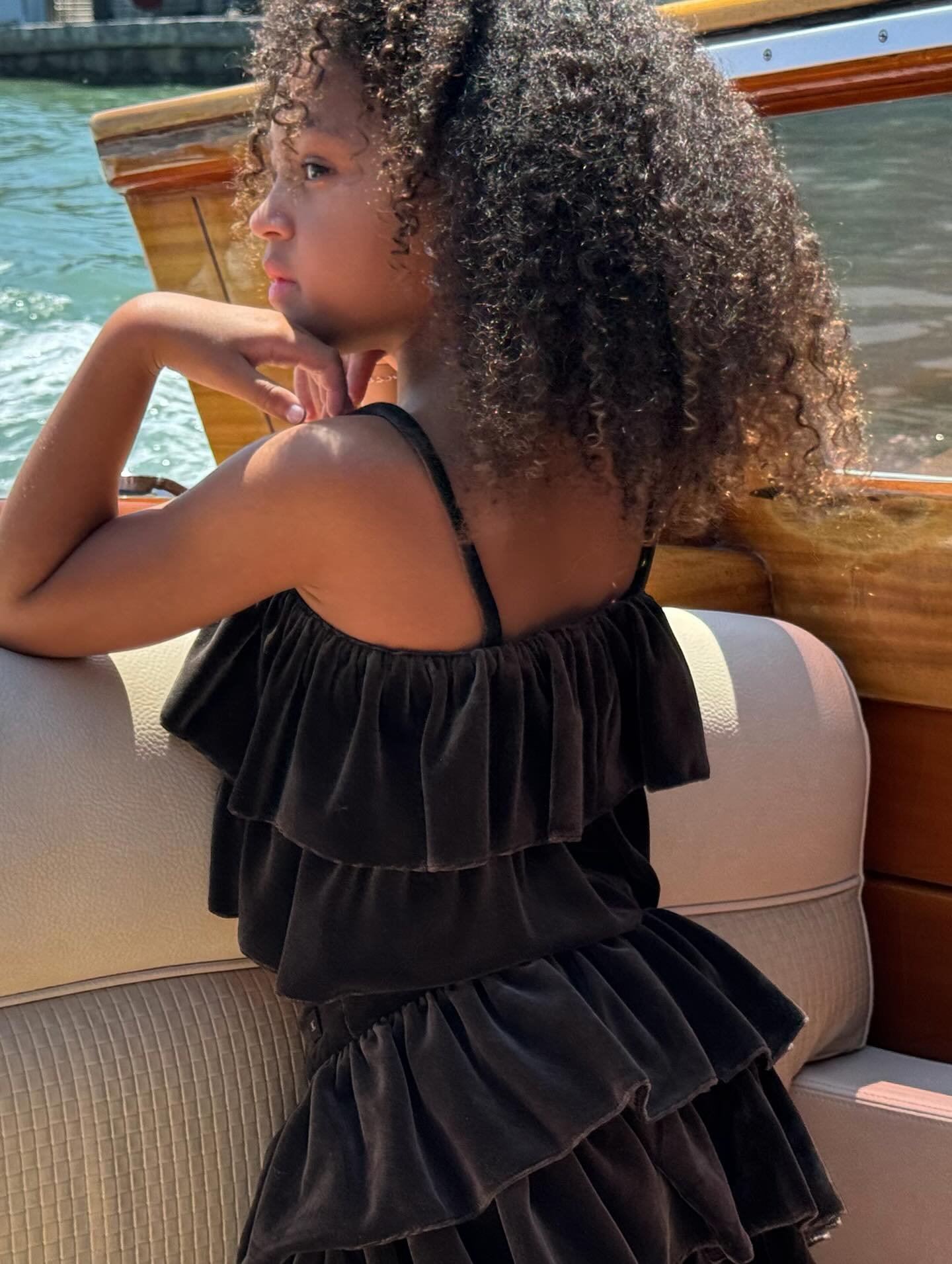 Stormi Webster in a boat, looking out at the water.