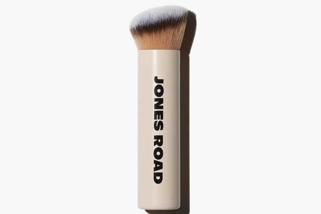 Jones Road makeup brush with a beige handle and black lettering.