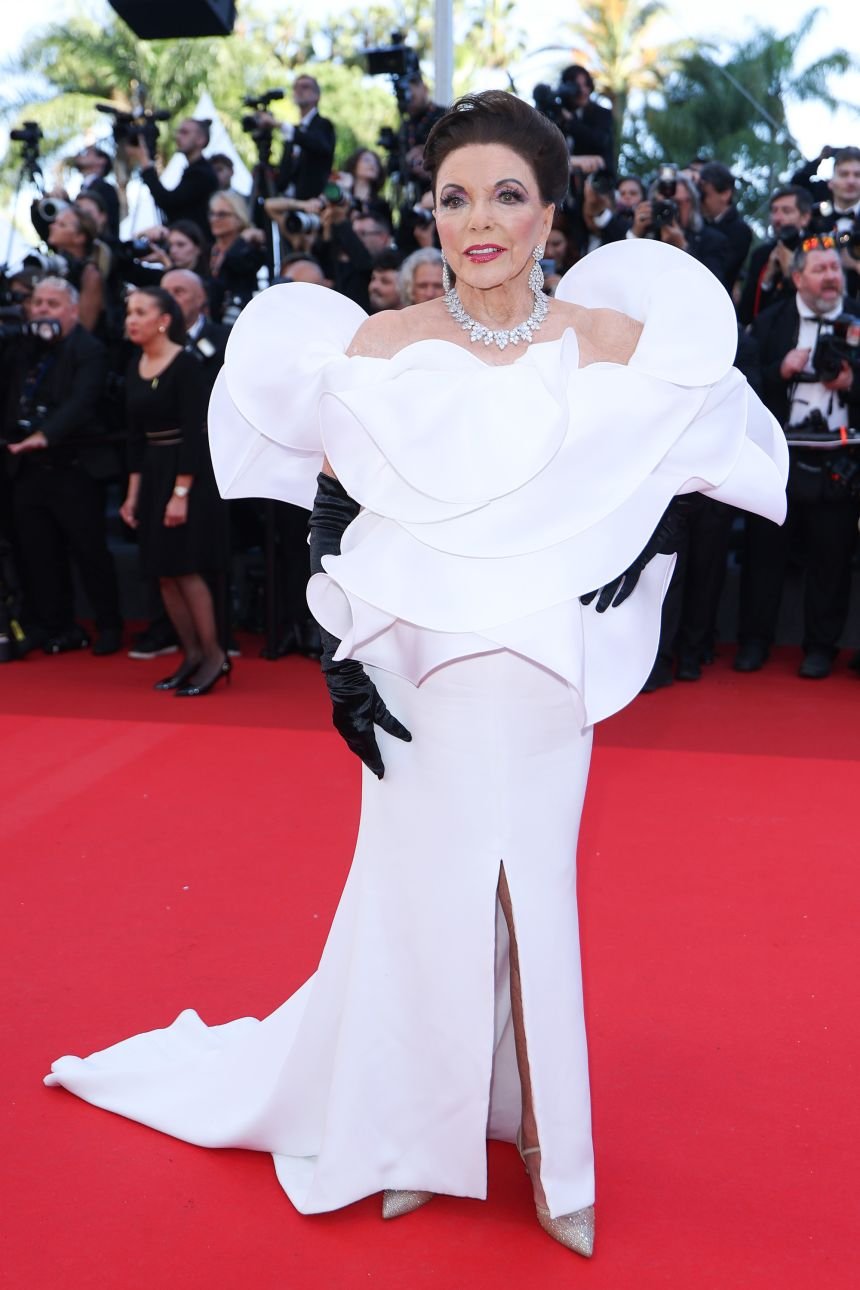 Joan Collins wore an orchid-inspired dress and black opera gloves by Stéphane Rolland at the opening night.