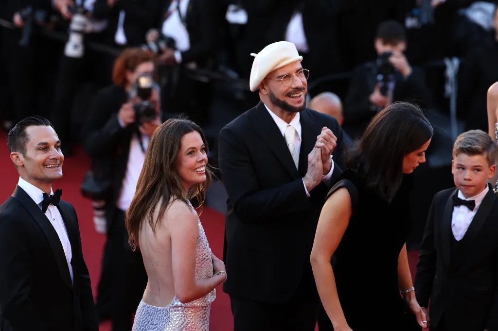 John Travolta Surprised with Honorary Palme d’Or at Cannes Premiere of His Directorial Debut ‘Propeller One-Way Night Coach’